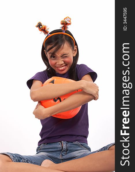A young girl hugging her pumpkin over a white background. A young girl hugging her pumpkin over a white background