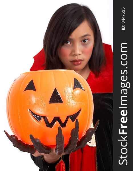 A young girl dressed in a halloween costume holding a pumpkin. A young girl dressed in a halloween costume holding a pumpkin