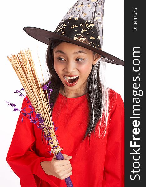 A young witch surprisingly looking at her broomstick