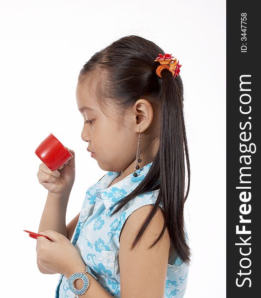 Girl playing with a toy tea cup and saucer