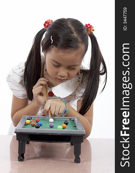 A young girl playing a toy billiards set. A young girl playing a toy billiards set