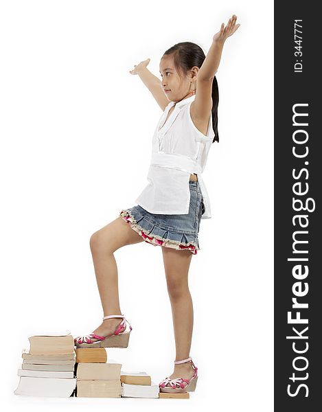 A girl climbing up by stepping on book stacks. A girl climbing up by stepping on book stacks