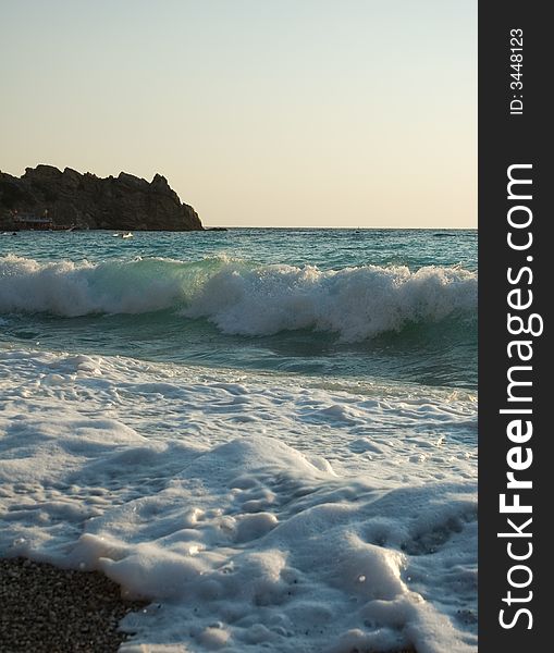 Waves of the azure Mediterranian sea rolling on the pebble beach. Waves of the azure Mediterranian sea rolling on the pebble beach