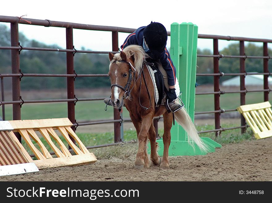 Small child leaning to pet pony after a ride in show. Small child leaning to pet pony after a ride in show