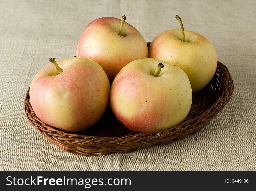 Yellow red apples in wicker tray