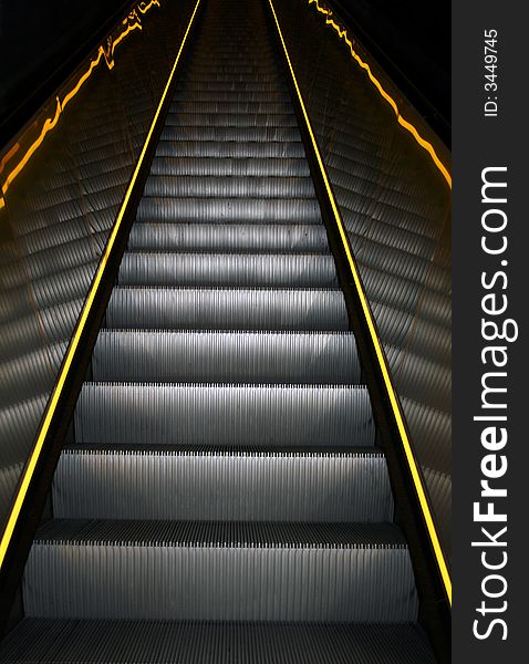 A escalator with yellow stripes on the sides