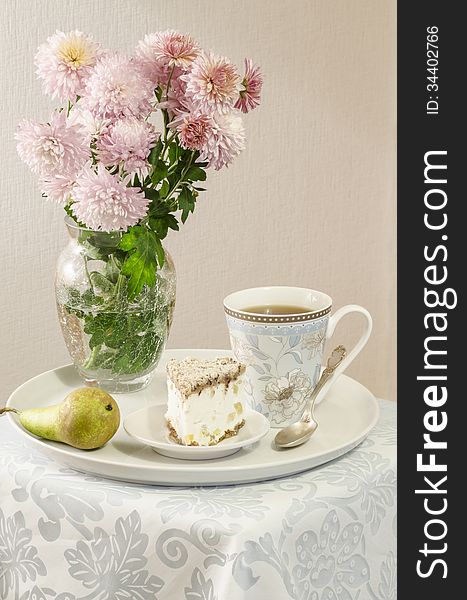 Ricotta and Pear Cake with cup of tea and bouquet of chrysanthemums. From the series Italian desserts