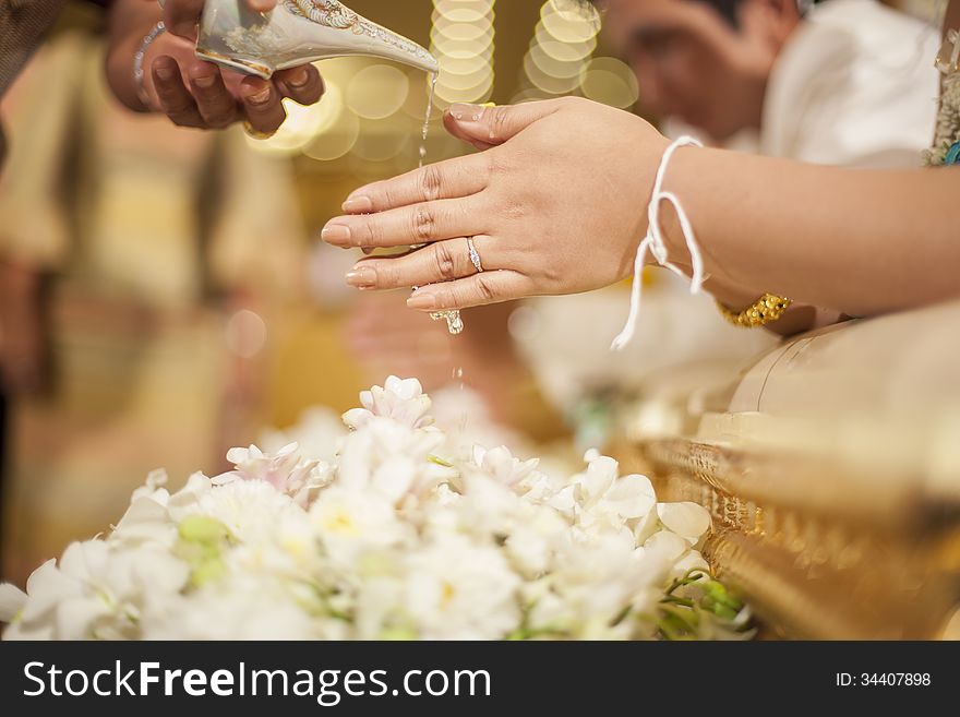 Hands pouring blessing water into bride's bands, Thai wedding ceremony. Hands pouring blessing water into bride's bands, Thai wedding ceremony