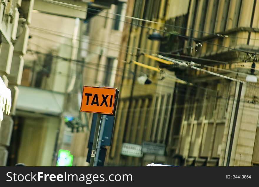 Taxi sign on road with city background