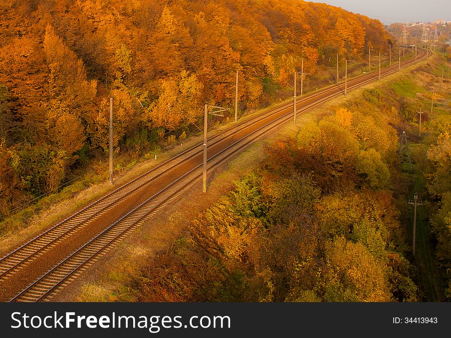 Autumn landscape and sunlit railroad