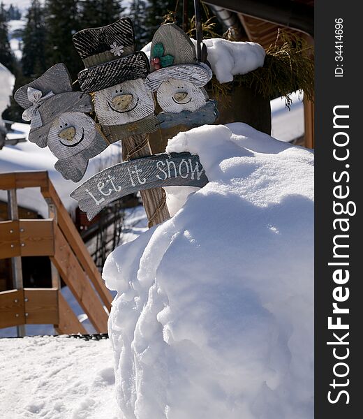 Cute snowmen let it snow sign in a big pile of snow