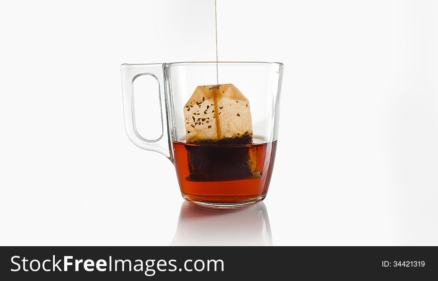 A red teabag in a crystal cup