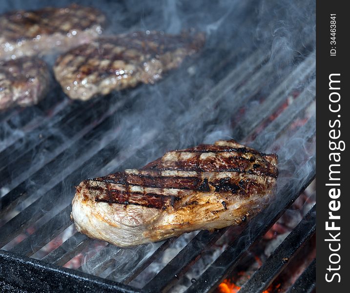 Beef steak cooking on an open flame grill