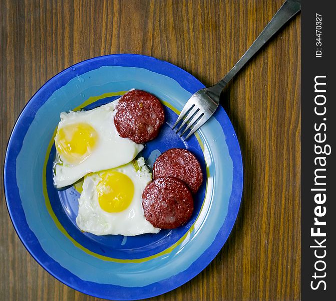 Fried eggs on a plate with slices of fried bacon