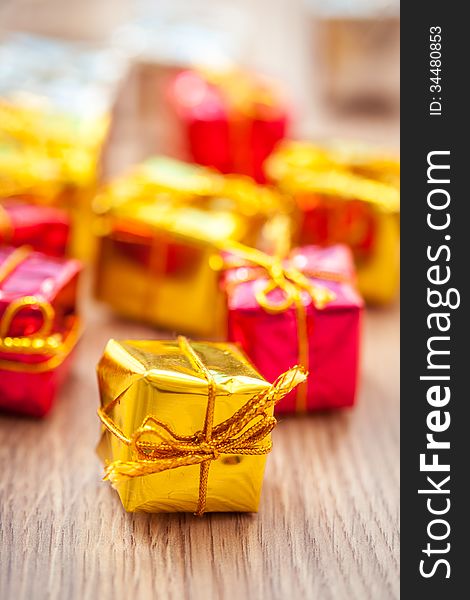 Multicolored decorative gifts on wooden background
