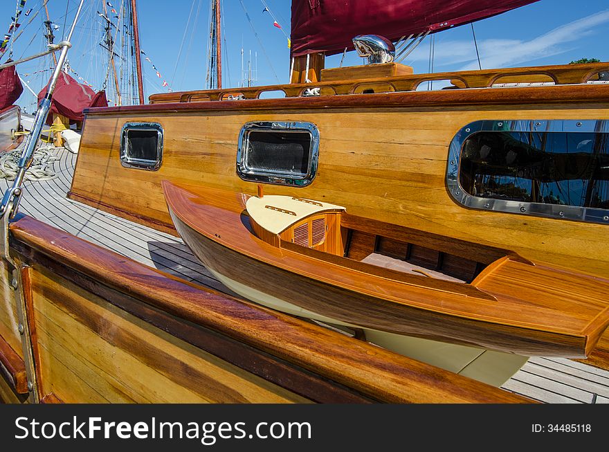 Beautifully restored classic sail boat docked at a marina on a summer sunny day.