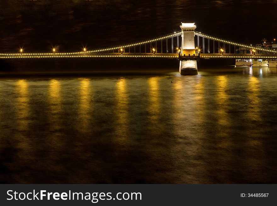 Bridge over the Danube river in Budapest with water reflections. Bridge over the Danube river in Budapest with water reflections