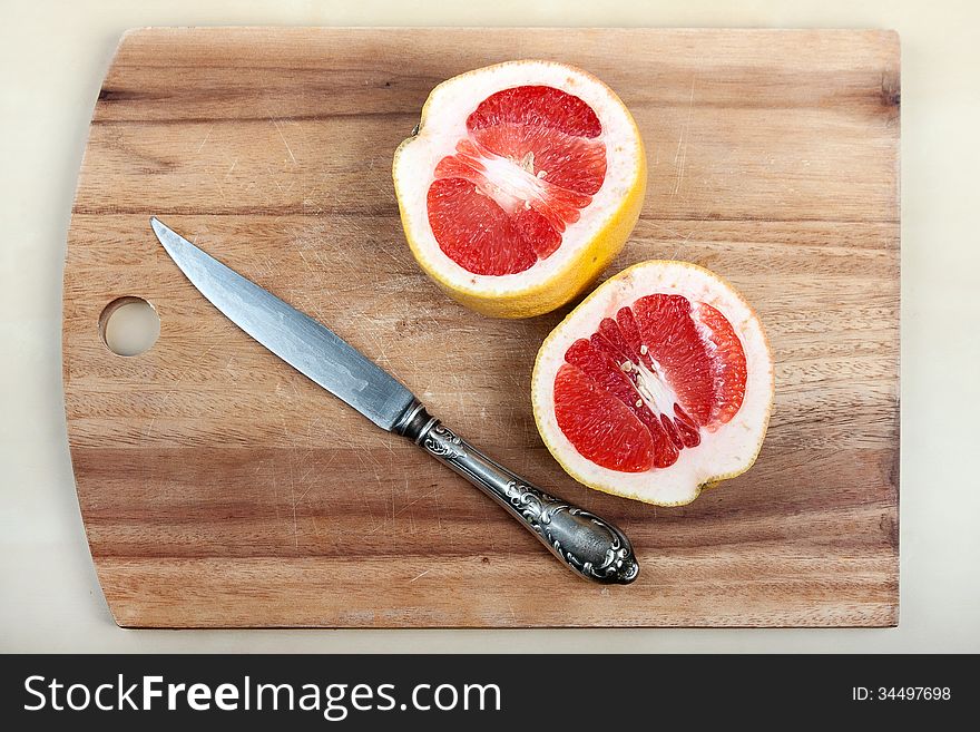 The cut grapefruit on a chopping board