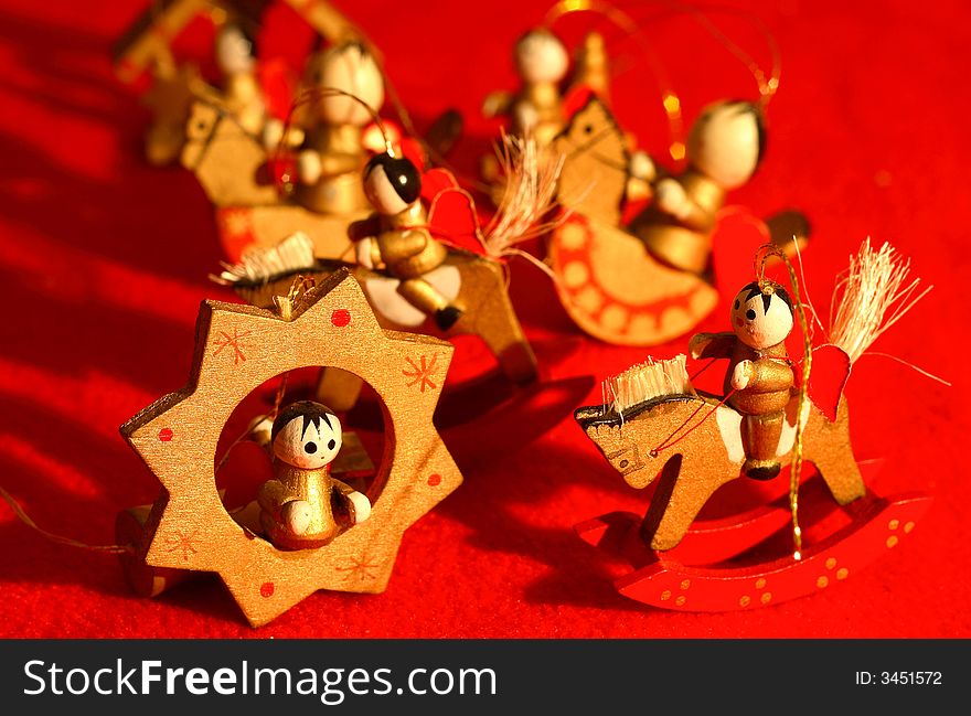 Little wooden new-year toys, wooden little angels on a red background