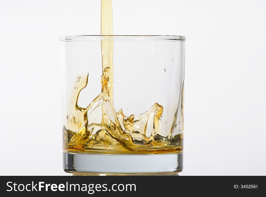 Glass being filled with coloured liquid on white background. Glass being filled with coloured liquid on white background