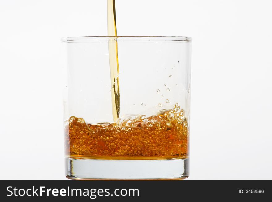 Glass being filled with coloured liquid on white background. Glass being filled with coloured liquid on white background