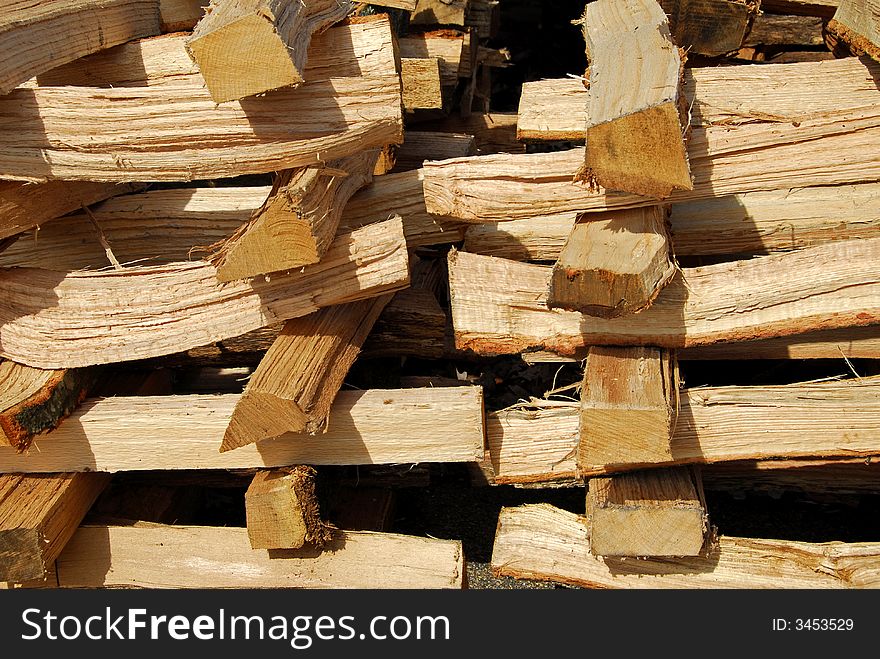 A stack of cut hardwood for fire place or stove in the winter. A stack of cut hardwood for fire place or stove in the winter