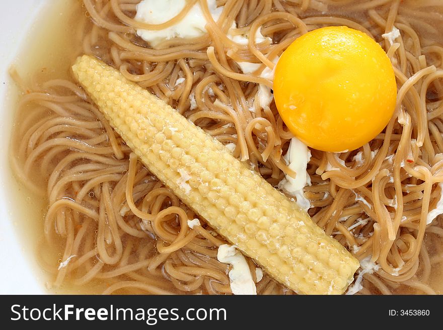 Brown Chinese buckwheat noodles with egg and baby corn in light soup