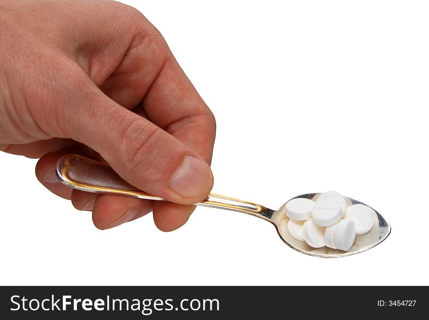 Spoon with pills in hand isolated on white