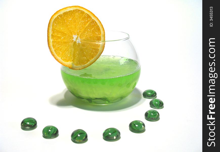 Sphere glass filled with bright green shower gel and green glass pebbles with juicy orange. Sphere glass filled with bright green shower gel and green glass pebbles with juicy orange
