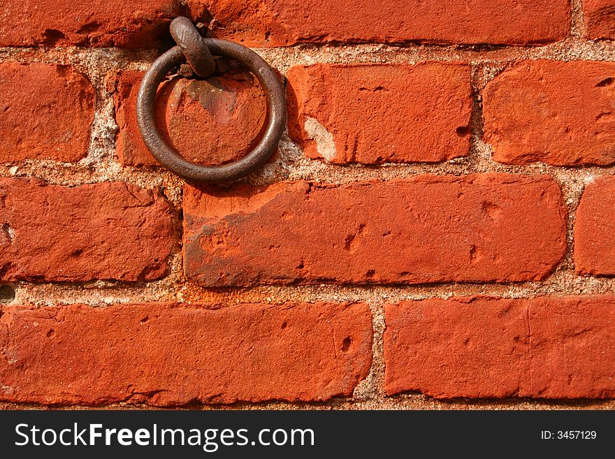 A Red Brick Wall with a Rusty Ring is Displayed. A Red Brick Wall with a Rusty Ring is Displayed.