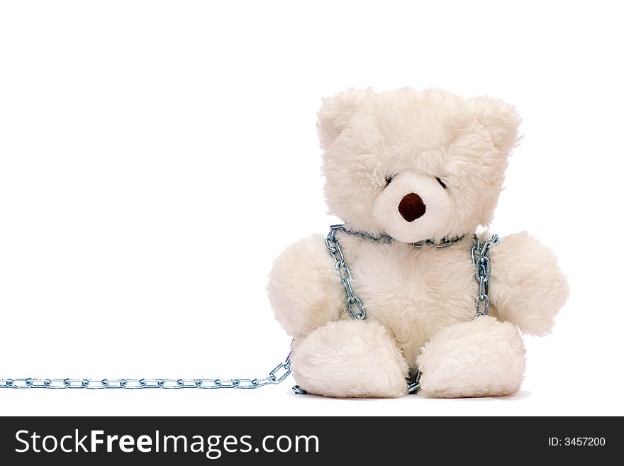 A toy teddy bear in chains  on a white background . A toy teddy bear in chains  on a white background .