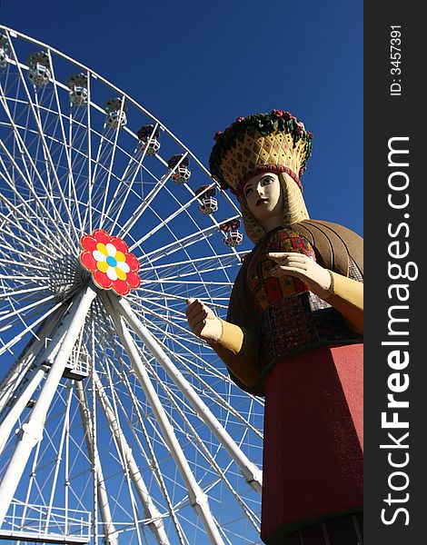 Wooden sculpture of a flower girl in front of a ferries wheel in Vienna's amusement park, the Prater. Wooden sculpture of a flower girl in front of a ferries wheel in Vienna's amusement park, the Prater