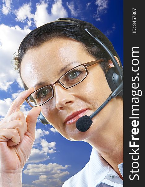 View of nice operator in stylish glasses on blue sky back. View of nice operator in stylish glasses on blue sky back