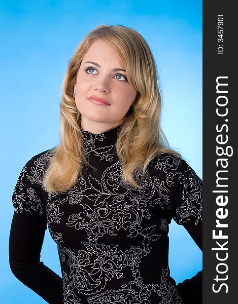 The beauty blonde in the studio, isolated on a blue background. The beauty blonde in the studio, isolated on a blue background.