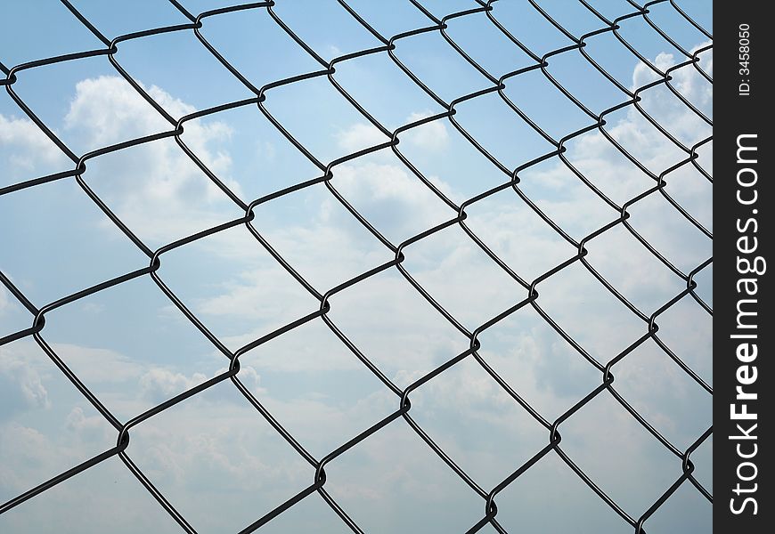 Metallic wire net with a blue sky on background