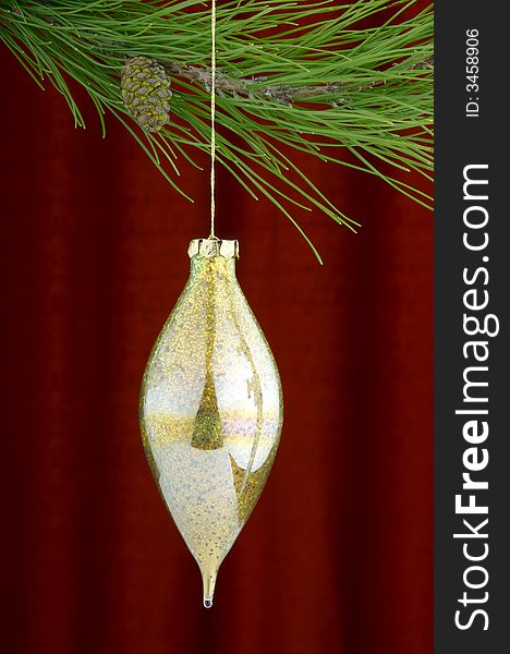 An image of gold Christmas ornaments on a burgundy background. An image of gold Christmas ornaments on a burgundy background