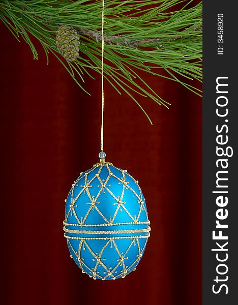 Christmas tree ornament with a pine tree branch in the top of the image, a blue hand made decoration being the main focus. Christmas tree ornament with a pine tree branch in the top of the image, a blue hand made decoration being the main focus