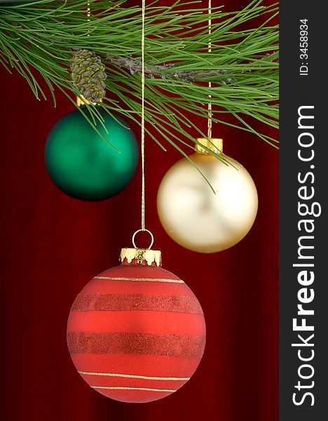 An image of multicolored Christmas ornaments on a burgundy background. An image of multicolored Christmas ornaments on a burgundy background