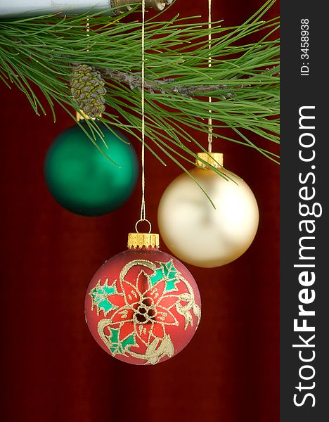 An image of multicolored Christmas ornaments on a burgundy background. An image of multicolored Christmas ornaments on a burgundy background