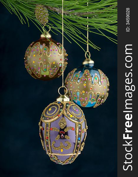 An image of multicolored Christmas ornaments on a burgundy background. An image of multicolored Christmas ornaments on a burgundy background