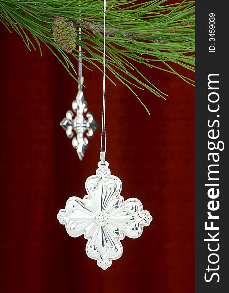 An image of silver Christmas ornaments on a burgundy background. An image of silver Christmas ornaments on a burgundy background