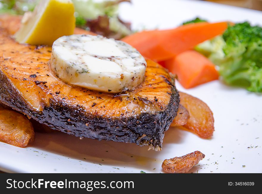 Grilled Butter Salmon with vegetables on a white plate