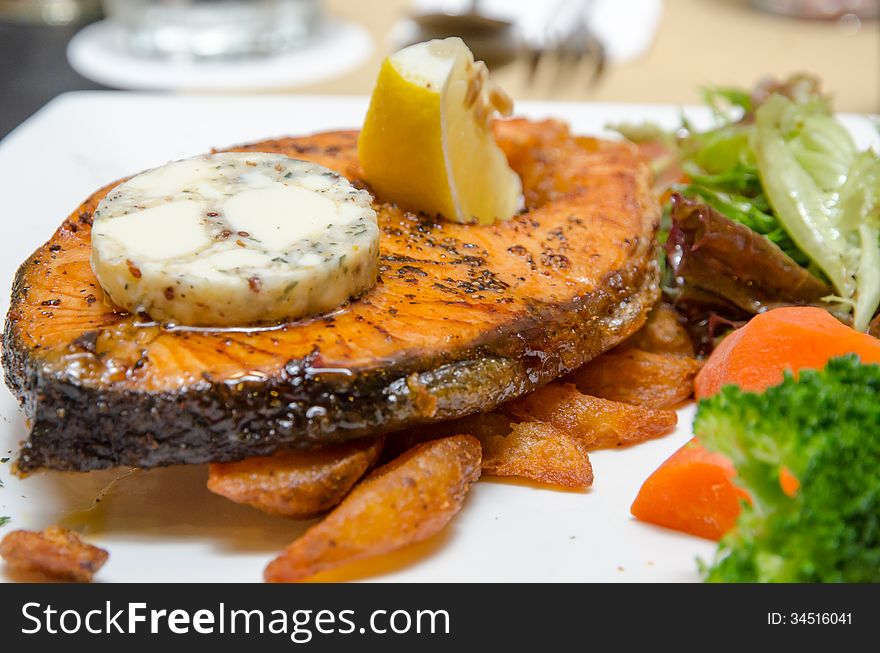 Grilled Butter Salmon with vegetables on a white plate