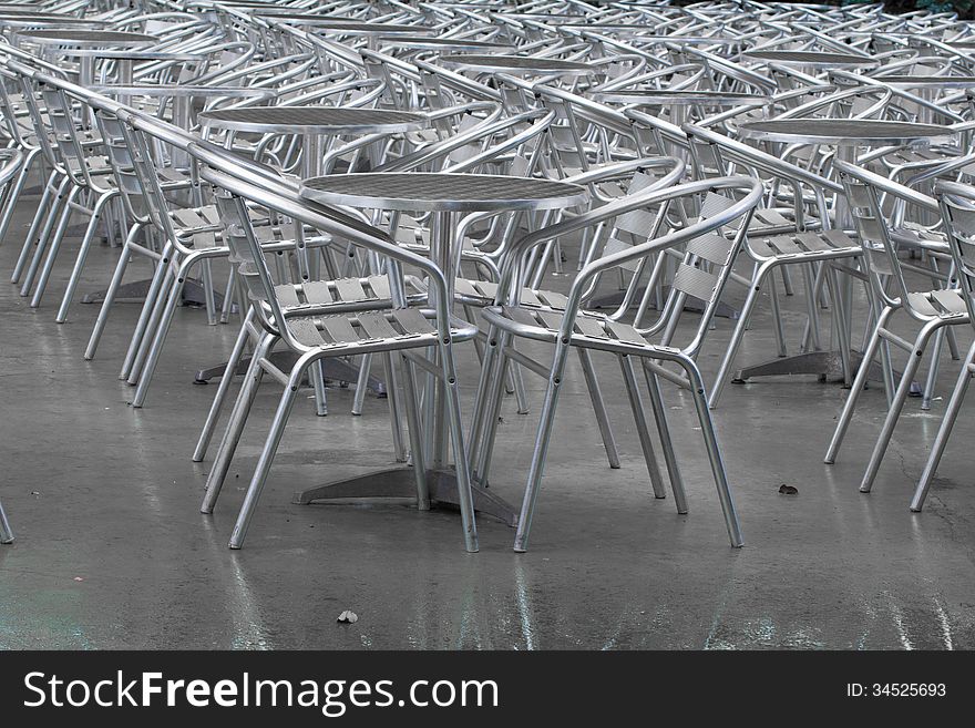 Row of empty silver tables and silver chairs outside a restaurant. Row of empty silver tables and silver chairs outside a restaurant