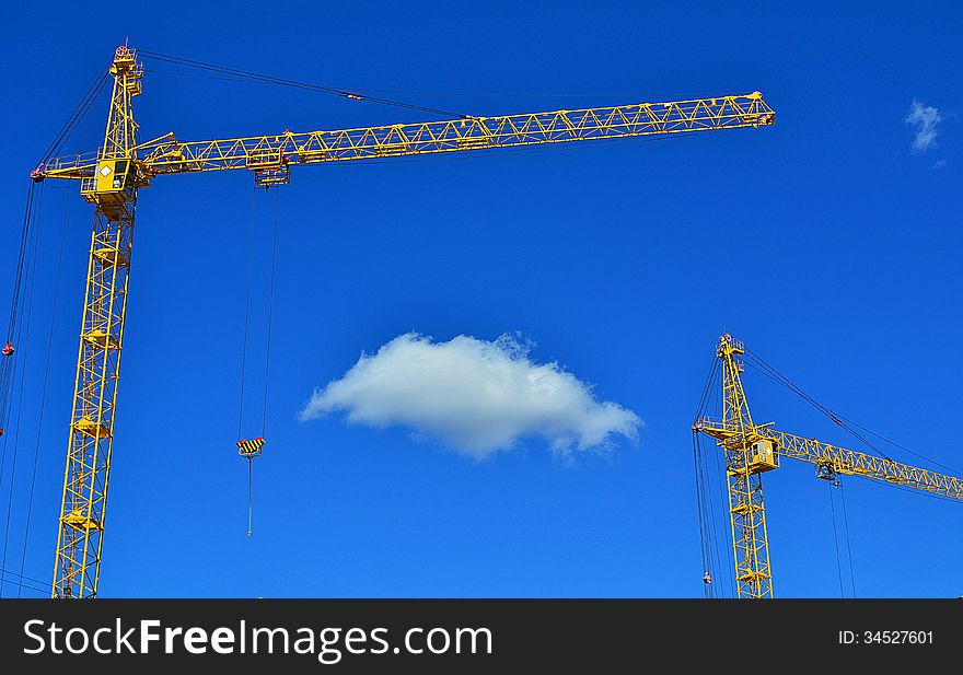 Cranes and cloud against the blue sky