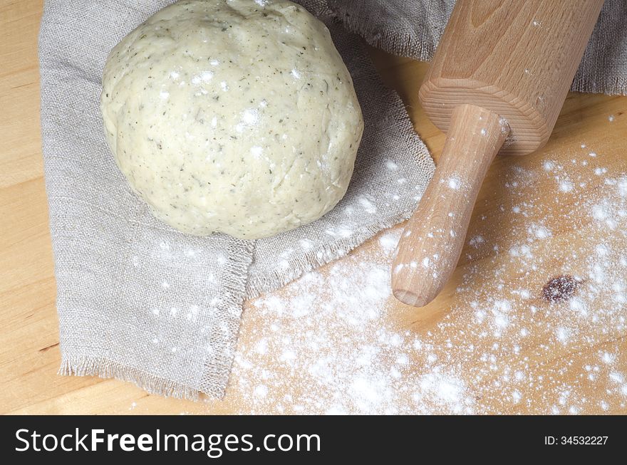 Dough, rolling pin and flour on a wooden table. From series Cooking vegetable pie