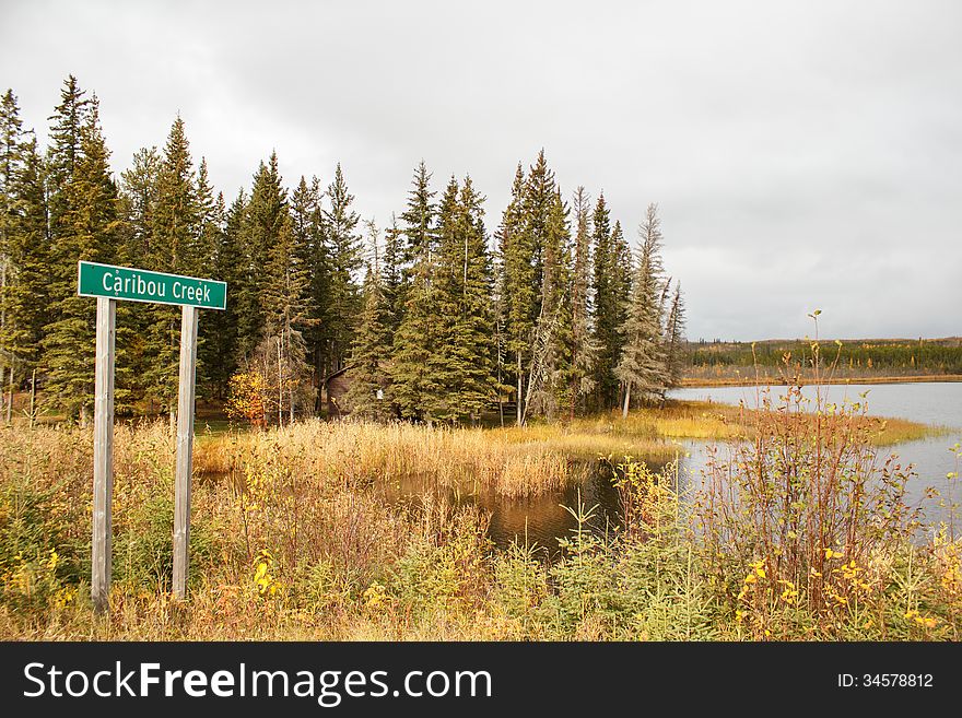 A sign announcing the name of the lake as caribou creek. A sign announcing the name of the lake as caribou creek