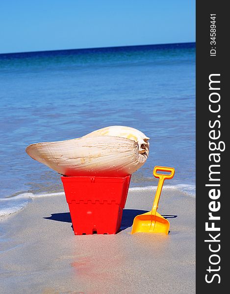 Bucket and spade and large shell on the beach. Bucket and spade and large shell on the beach