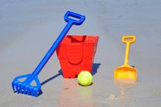 Red Bucket Spade Ball And Rake On The Beach In A G Royalty Free Stock Photography Red Bucket Spade Ball And Rake On The Beach In A G Royalty Free Stock Photography