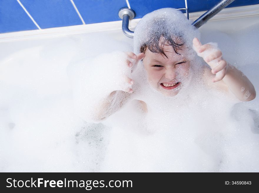 Little girl in bath. Soapsuds on all body and the head.